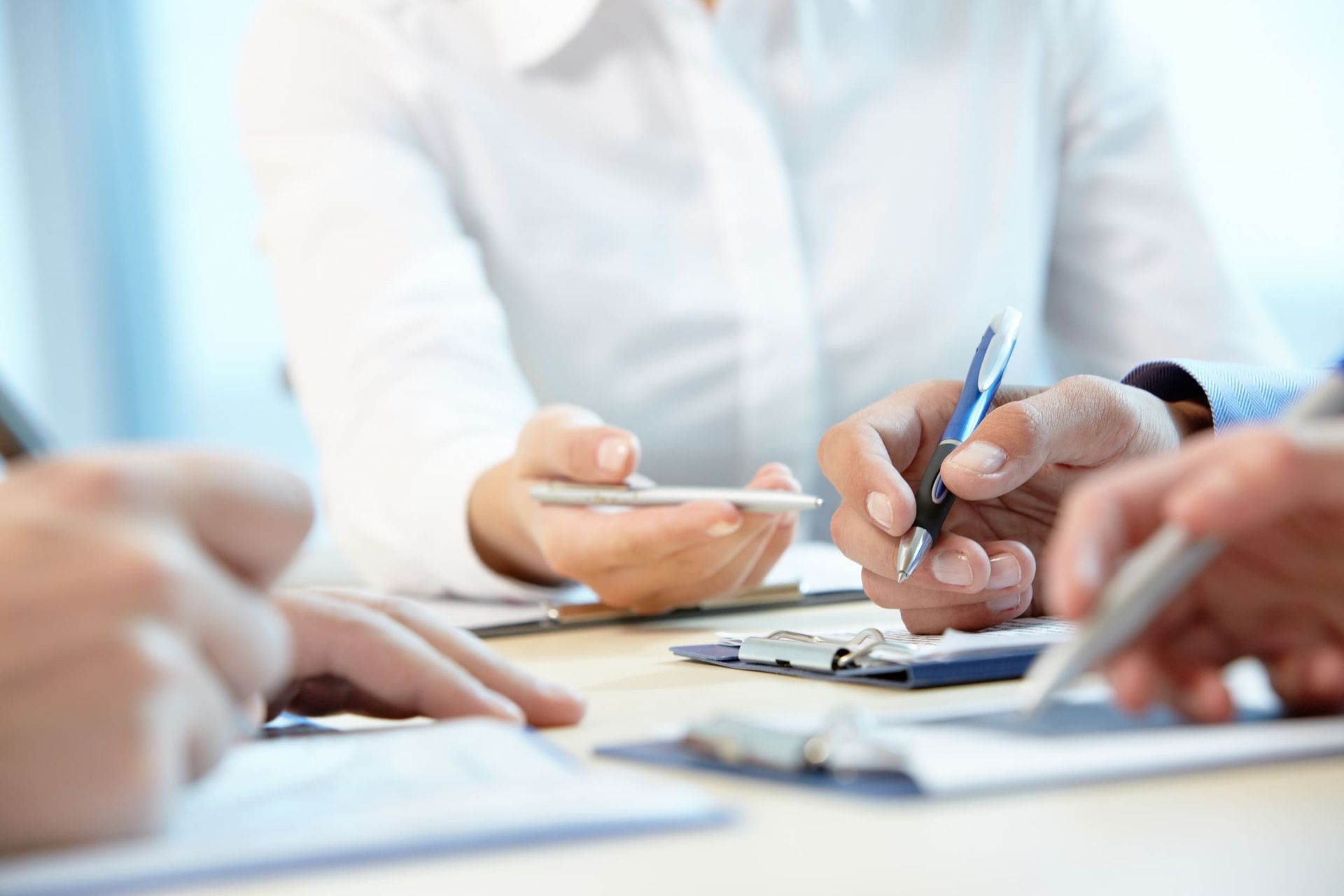 Nahaufnahme mehrerer Männerhände die Papiere miteinander besprechen