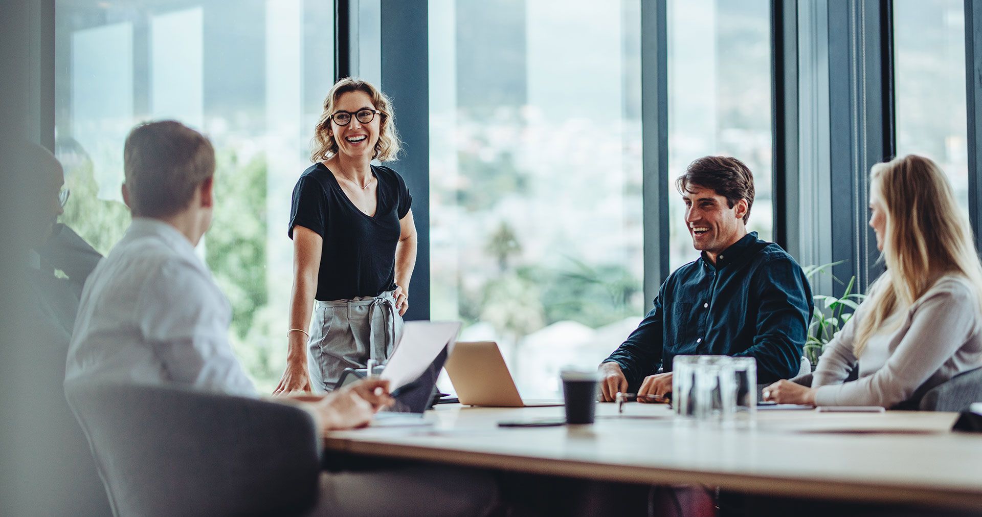 Eine Frau und drei Männer halten eine Konferenz in einem Konferenzraum